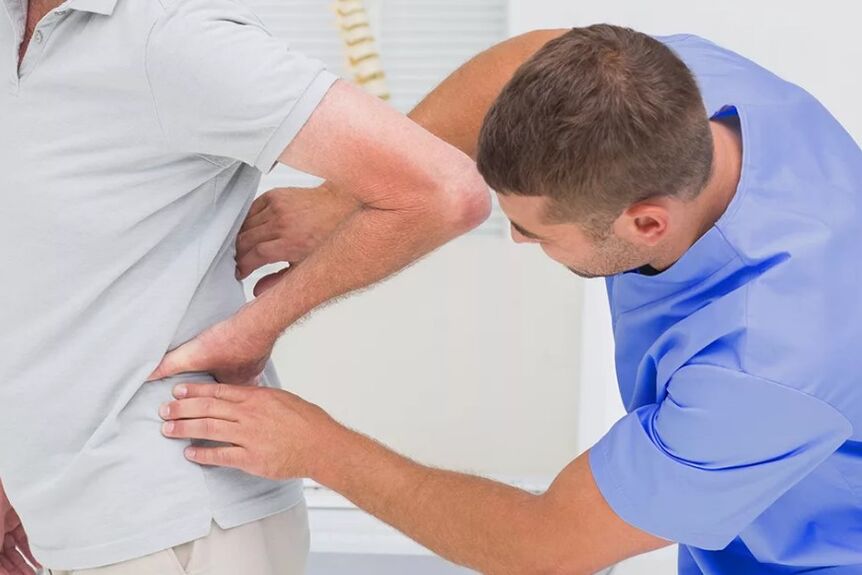 Ein Patient mit Lendenschmerzen bei einer diagnostischen Untersuchung durch einen Arzt